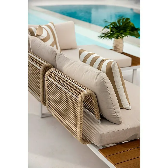 Conjunto de muebles Lynne - 3 pzs., Aluminio/Polywood/Poliéster, Blanco/Beige - Tumbona de exterior con cojines beige, reposabrazos de cuerda trenzada y elementos de madera, junto a una piscina.