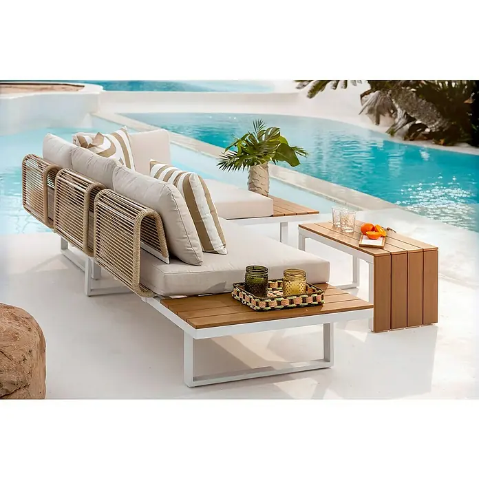 Conjunto de muebles Lynne - 3 pzs., Aluminio/Polywood/Poliéster, Blanco/Beige - Sofá lounge de exterior con estructura blanca, trenzado de cuerda beige, cojines claros y mesas auxiliares de madera integradas, junto a la piscina.