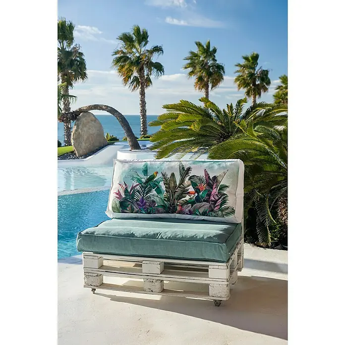 Set cojines para palet Selva - 120 x 80 x 16 cm, Multicolor, 50% algodón 50% poliéster, 2 ud. - Sofá de palets blanco con cojines azul verdoso y respaldo de estampado tropical, junto a una piscina con palmeras y el mar.