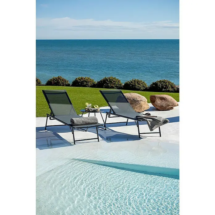 Tumbona de jardín Belisa - Gris oscuro, Acero, Abatible - Dos tumbonas de malla gris oscuro y metal negro con mesa auxiliar junto a una piscina.