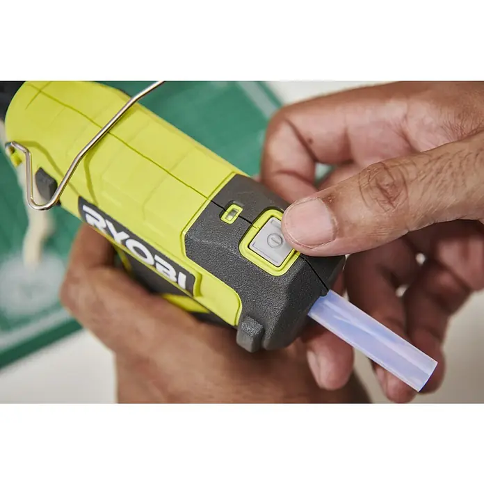 Ryobi 4V USB Akku-Heißklebepistole RGLU4-0 - 4 V, Ohne Akku, Durchmesser Klebepatrone: 11 mm - Eine Hand bedient eine gelb-schwarze Ryobi Heißklebepistole mit einem transparenten Klebestift.