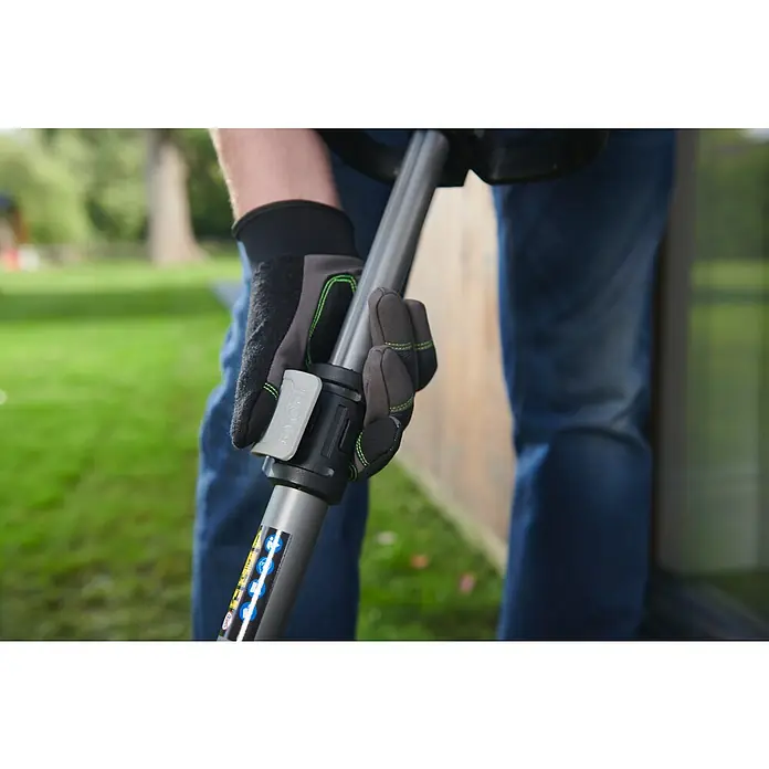 Ryobi ONE+ Akku-Fugenreiniger RY18PCC-0 - Ohne Akku - Person in schwarz-grauen Handschuhen betätigt die Schnellkupplung eines grauen Ryobi-Geräteschafts mit Sicherheitsetiketten.