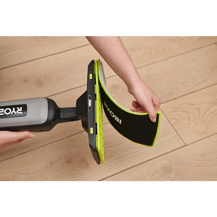 Ryobi Akku-Wischmopp mit Sprühfunktion RSM4-120G - 4 V, 1 Akku, 2 Ah - Eine Hand befestigt ein schwarzes und grünes RYOBI Reinigungspad an einem grauen Handgerät.