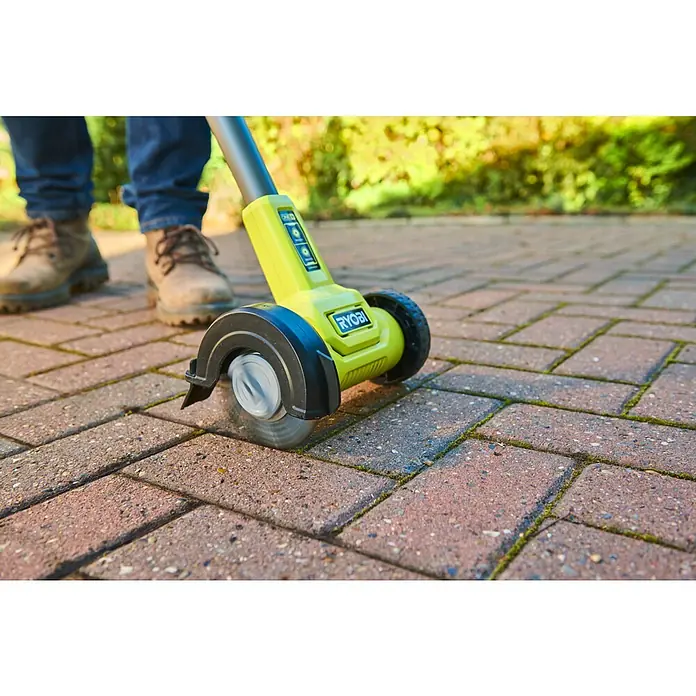 Ryobi ONE+ Akku-Fugenreiniger RY18PCC-0 - Ohne Akku - Person benutzt einen lindgrünen Ryobi Terrassenreiniger mit rotierender Bürste, um Moos von Pflastersteinen zu entfernen.