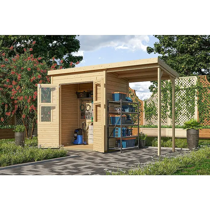 Karibu Gartenhaus Timmo - Außenmaß inkl. Dachüberstand (B x T): 329 x 142 cm, Holz, Natur, Mit Anbau - Heller Holz-Gartenschuppen mit offenem Anbau, gefüllt mit Werkzeugen und Regalen, an einem gepflasterten Weg in einem grünen Garten.