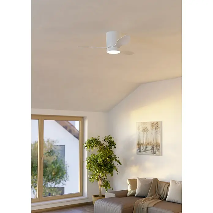 Eglo Deckenventilator Baracarès - Weiß, 91 cm - Moderner weißer Deckenventilator mit integrierter LED-Leuchte, in einem Wohnzimmer mit Dachschräge installiert.