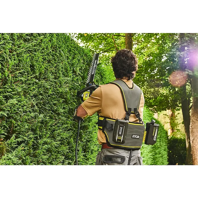 Ryobi Max Power Gürtel RY36BB2PA - Passend für: Zwei 36 V Akkus - Person trimmt eine Hecke mit einem Ryobi Heckenschneider und trägt ein Geschirr mit Ryobi Akkus.