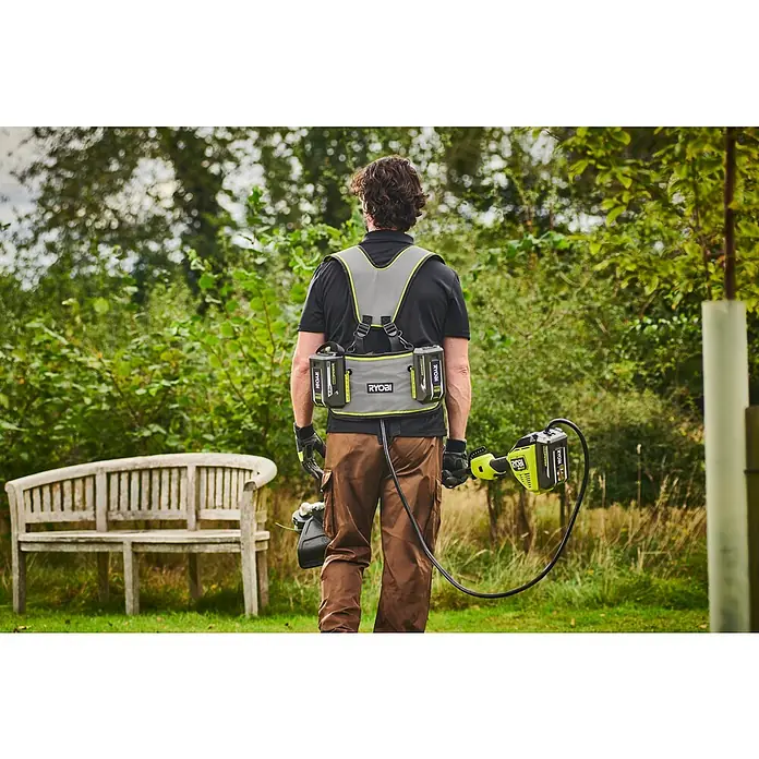 Ryobi Max Power Gürtel RY36BB2PA - Passend für: Zwei 36 V Akkus - Mann mit grau-grünem Ryobi Akku-Gurt mit zwei Akkus, hält einen Ryobi Rasentrimmer im Garten.