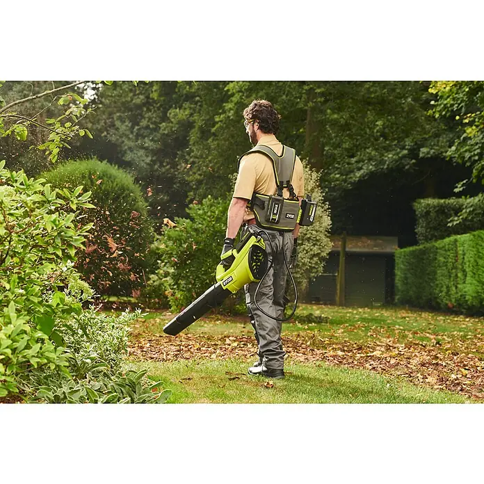 Ryobi Max Power Gürtel RY36BB2PA - Passend für: Zwei 36 V Akkus - Limettengrüner Ryobi Laubbläser mit Akku-Gurtzeug, von einer Person zum Laubblasen im Garten verwendet.