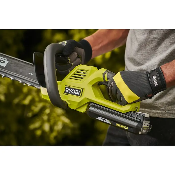 Ryobi Max Power Akku-Heckenschere RY36HT60A - 36 V, Li-Ionen, Ohne Akku, Schnittlänge: 60 cm - Eine Person mit Handschuhen hält eine limettengrüne und schwarze Ryobi Akku-Kettensäge mit 2,0Ah Akku.