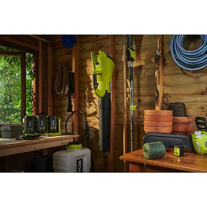 Ryobi Max Power Akku-Gebläse RY36BLB - 36 V, Ohne Akku, Blasgeschwindigkeit: 193 km/h - Ryobi Elektrowerkzeuge (Laubbläser, Astsäge, Kettensäge, Akkus) und Gartenzubehör in einem rustikalen Holzschuppen.
