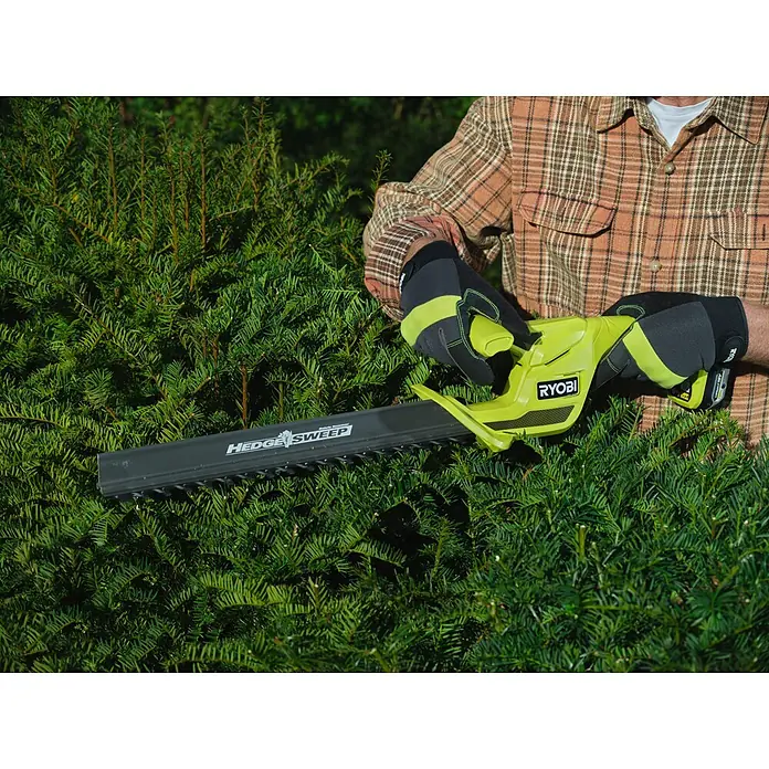Ryobi ONE+ Akku-Heckenschere RY18HT40B-0 - Li-Ionen, Ohne Akku, Schnittlänge: 40 cm - Gelb-schwarzer Ryobi Heckenschneider mit „HEDGE SWEEP“-Klinge, der von einer Person zum Trimmen einer dichten grünen Hecke verwendet wird.