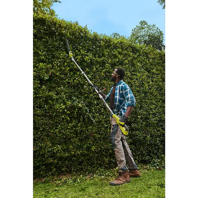 Ryobi ONE+ Teleskop-Heckenschere RY18PHT40A-0 - 18 V, Li-Ionen, Anzahl Akkus: Ohne Akku, Schnittlänge: 40 cm - Eine Person trimmt mit einer gelb-grauen Stielheckenschere eine hohe Hecke.