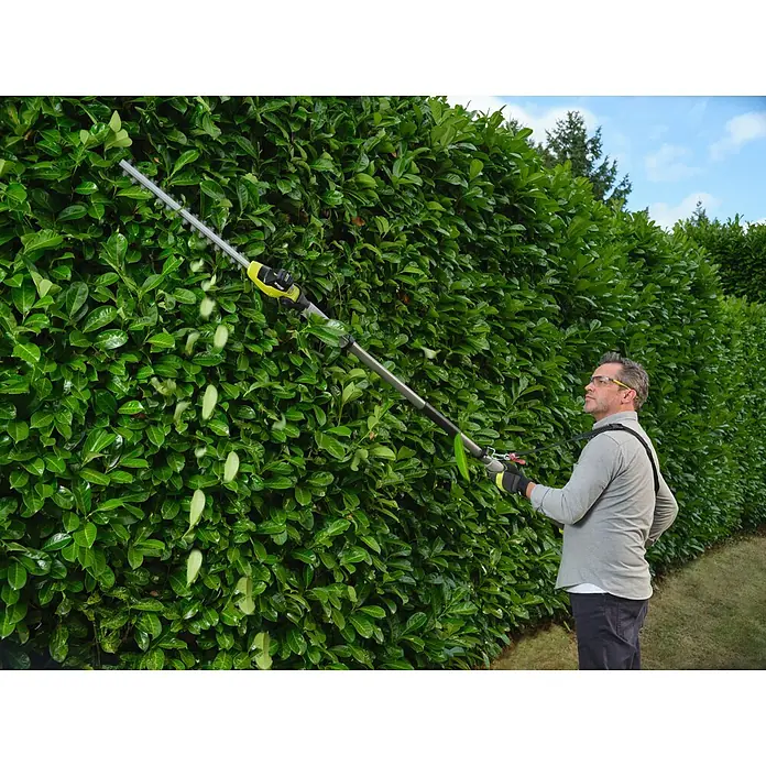 Ryobi ONE+ Teleskop-Heckenschere RY18PHTX45A - 18 V, Li-Ionen, Anzahl Akkus: Ohne Akku - Mann trimmt eine hohe grüne Hecke mit einer gelb-grauen Teleskop-Heckenschere.