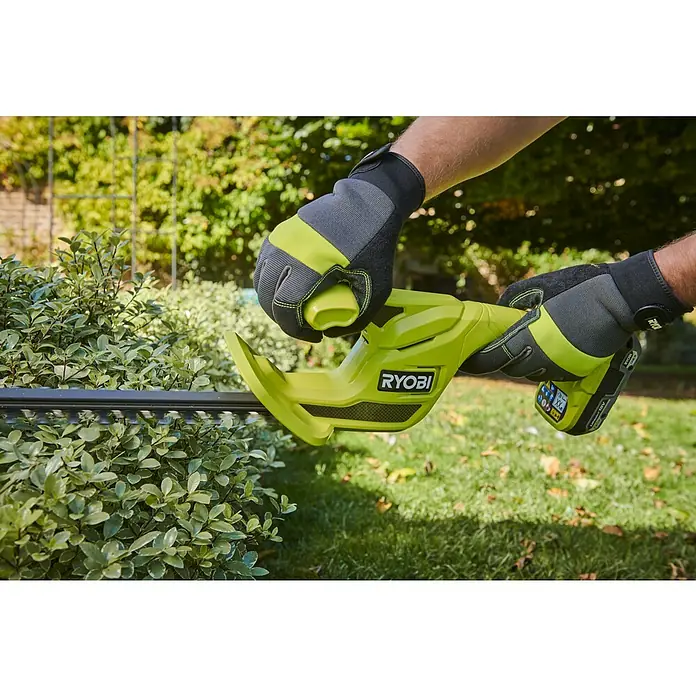 Ryobi ONE+ Akku-Heckenschere RY18HT40B-0 - Li-Ionen, Ohne Akku, Schnittlänge: 40 cm - Eine Person mit grau-lindgrünen Handschuhen benutzt eine lindgrün-schwarze Ryobi Heckenschere, um eine grüne Hecke zu schneiden.