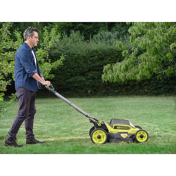 Ryobi ONE+ Akku-Rasenmäher RY18LMXSP51A - 18 V, Ohne Akku, Schnittbreite: 51 cm - Mann mäht den Rasen mit einem grün-schwarzen 2x 18V ONE+ Akku-Rasenmäher.
