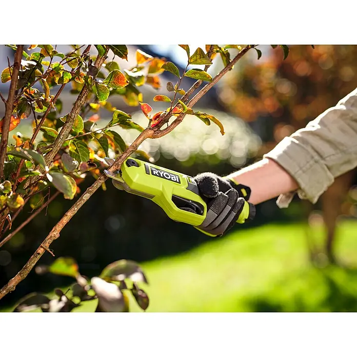 Ryobi Akku-Astschere RY4SCA-120 - 4 V, 1 Akku, 2 Ah, Max. Aststärke: 13 mm - Hand im Handschuh schneidet mit limettengrüner Ryobi Astschere einen kleinen Ast.