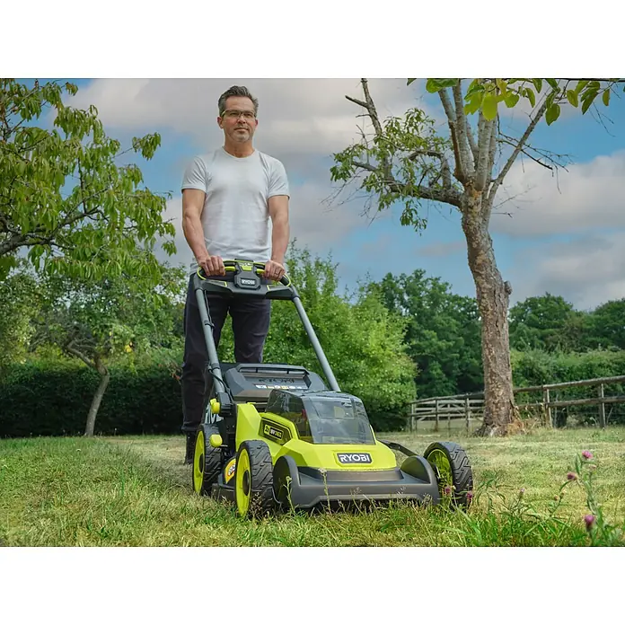 Ryobi ONE+ Akku-Rasenmäher RY18LMXSP51A - 18 V, Ohne Akku, Schnittbreite: 51 cm - Ein Mann bedient einen grünen und schwarzen Ryobi Akku-Rasenmäher.