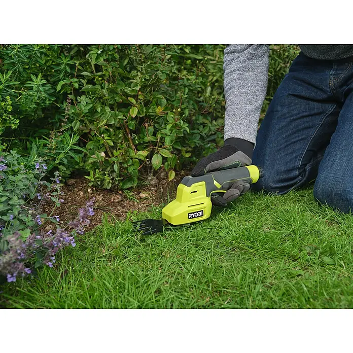 Ryobi Akku-Gras- & Strauchschere RY4CGSA-120 - Li-Ionen, 1 Akku - Eine Person kniet und trimmt mit einem limettengrünen und grauen Ryobi Hand-Rasentrimmer Gras am Rand eines Blumenbeets.