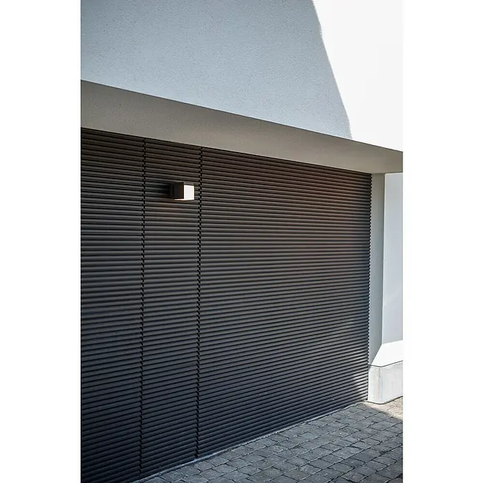 Lutec Aplique de pared LED Cuba - L x An x Al: 116 x 100 x 148 mm, Blanco neutro, Temperatura del color: 4.000 K, 500 lm - Puerta de garaje oscura de lamas horizontales con una lámpara de pared cúbica en una fachada moderna.