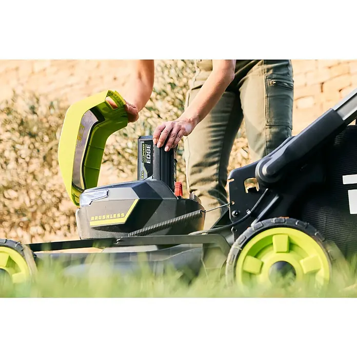 Ryobi Max Power Akku RY36BET80A - 36 V, 8 Ah, Li-Ionen - Person steckt einen schwarzen und grünen 8Ah MAX POWER EDGE Akku in einen grünen und schwarzen BRUSHLESS Akku-Rasenmäher.