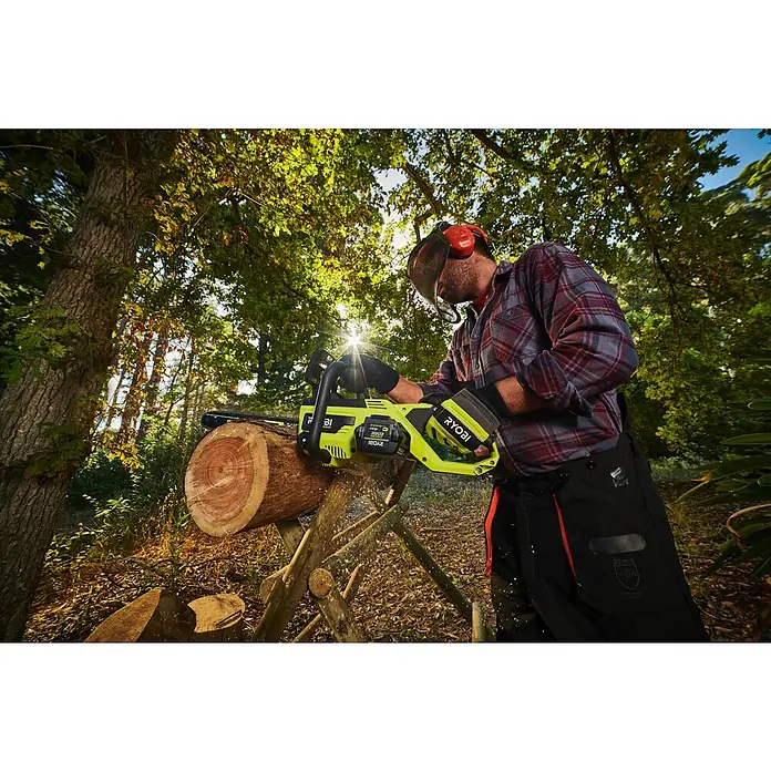 Ryobi Max Power Akku RY36BET40A - 36 V, 4 Ah, Li-Ionen - Eine Person in Schutzkleidung sägt Holz mit einer grün-schwarzen Ryobi Kettensäge in einem sonnigen Wald.
