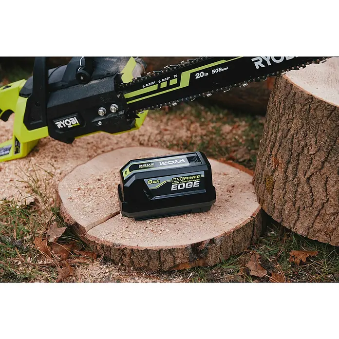 Ryobi Max Power Akku RY36BET80A - 36 V, 8 Ah, Li-Ionen - Ryobi grüne Akku-Kettensäge mit 508mm Schwert und 8Ah Max Power Edge Akku, auf einem frischen Holzstamm mit Sägespänen.