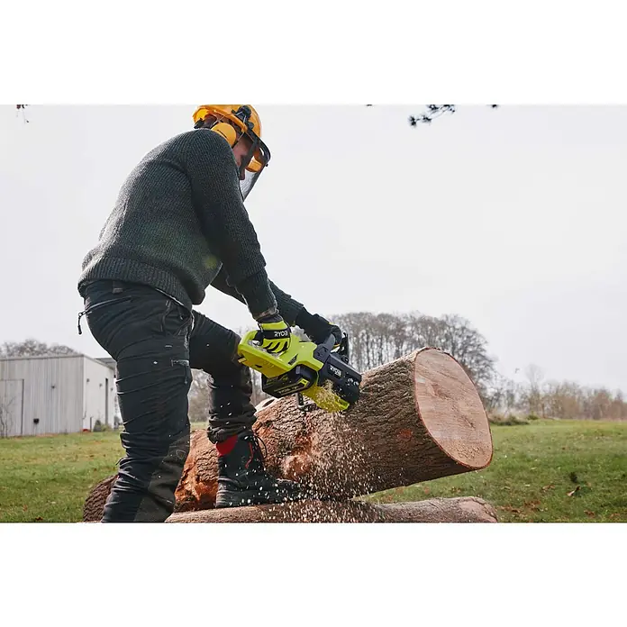 Ryobi Max Power Akku RY36BET80A - 36 V, 8 Ah, Li-Ionen - Person in Schutzausrüstung schneidet mit gelb-schwarzer Ryobi Kettensäge einen Holzstamm, Holzspäne fliegen.