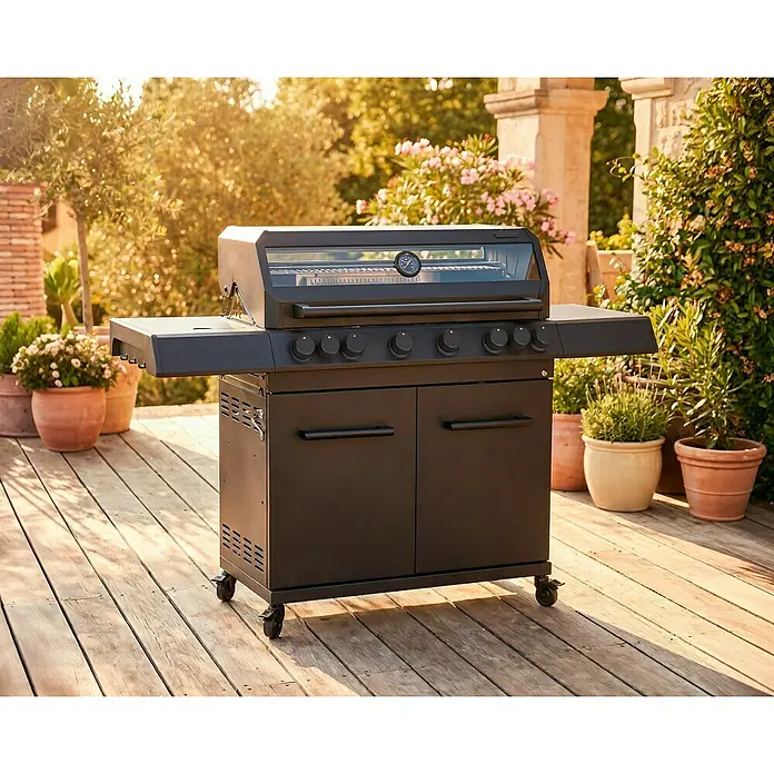 Kingstone KMS Gasgrill Cliff 6500 Beast Black Edition - Grillfläche (B x T): 90,5 x 45 cm, 21 kW, Anzahl Brenner: 6 Stk. - Schwarzer Gasgrill mit Glasdeckel und Thermometer, integriertem Schrank, auf Holzterrasse zwischen Pflanzen.