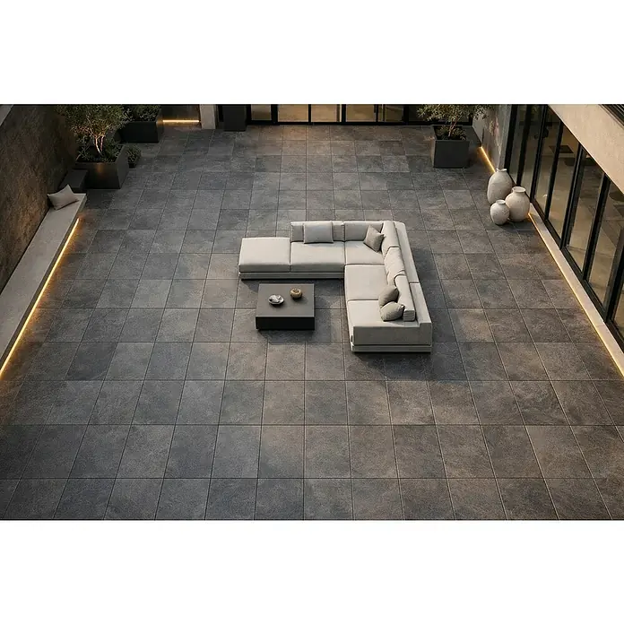 Terrassenfliese Museo Ardesia - 60 x 90 x 2 cm, Nera, Matt - Große, dunkelgraue, strukturierte Quadratfliesen bedecken eine moderne Außenterrasse und bieten eine langlebige und elegante Oberfläche.