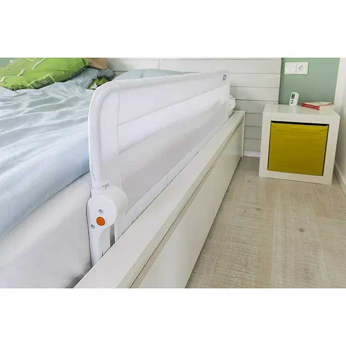 Abus Bettgitter Eric - Länge: 100 cm - Das Bild zeigt ein weißes Bettgitter, das an einem Bett befestigt ist, um die Sicherheit eines Kindes beim Schlafen zu gewährleisten.