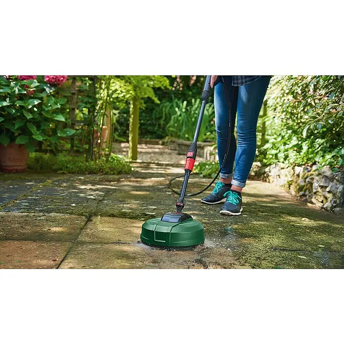 Bosch Terrassenreiniger Aquasurf 250 - Durchmesser: 250 mm, Passend für: Bosch Hochdruckreiniger Aquatak-Serie - Grüner und schwarzer Bosch Flächenreiniger, von einer Person zum Reinigen einer moosigen Terrasse verwendet.