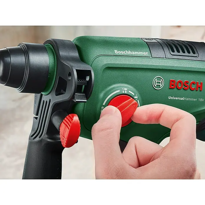 Bosch Power for All 18V Akku-Kombihammer UniversalHammer 18V - 18 V, Ohne Akku, 2 J, Mit Schnellspannbohrfutter - Nahaufnahme einer Hand, die den roten Moduswahlschalter an einem grünen Bosch UniversalHammer 18V einstellt.