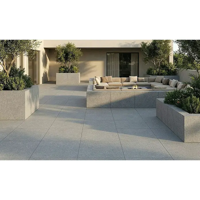 Terrassenfliese Fortezza - 60 x 60 x 2 cm, Diorit, Matt - Große graue quadratische Außenfliesen auf einer modernen Terrasse mit integrierten Sitzgelegenheiten und Pflanzgefäßen.
