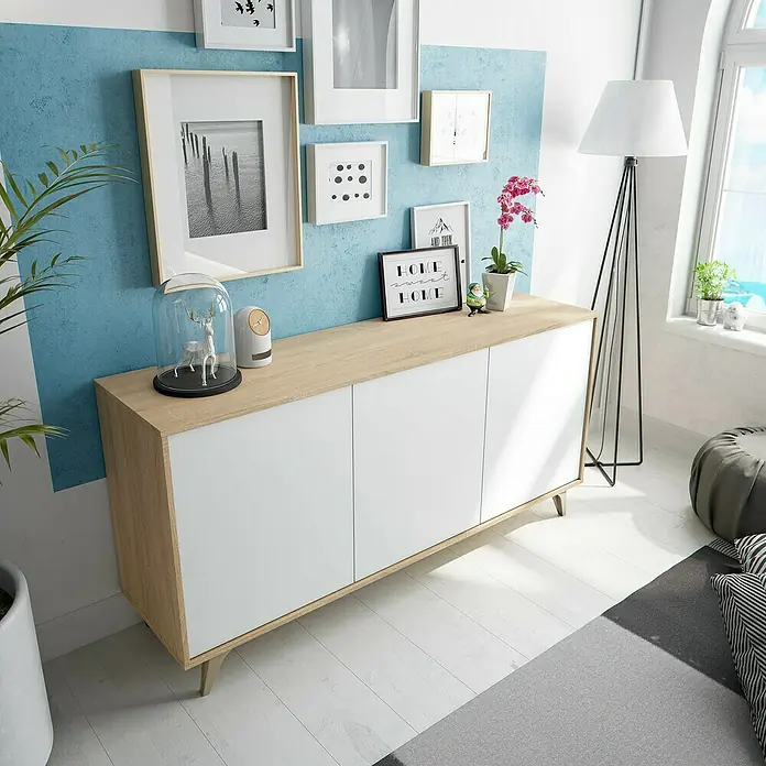 Aparador Kikua Plus - L x An x Al: 40 x 154 x 75 cm, Roble Canadian/Blanco Artik, Número de puertas: 3 ud. - Aparador de madera y blanco en una sala de estar, con tres puertas y patas anguladas.