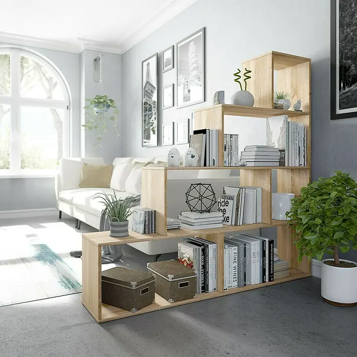 Estantería de madera Klum - L x An x Al: 29 mm x 145 cm x 145 cm, Roble Canadian - Estantería escalonada de madera clara en un salón moderno, llena de libros, plantas y decoración. Almacenamiento elegante.