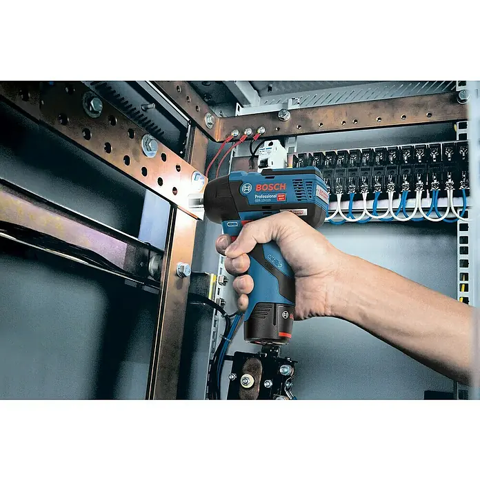Bosch Professional Akku-Drehschlagschrauber - 12 V, Ohne Akku, 115 Nm - Eine Hand bedient einen blauen und schwarzen Bosch Professional Akku-Schlagschrauber an elektrischen Komponenten.