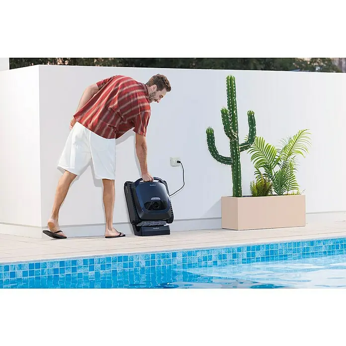 Beatbot Poolroboter AquaSense 2 - Akkubetrieben, Passend für: Pools bis 300 m² Grundfläche, Filterleistung: 20.800 l/h - Mann bereitet schwarzen Roboter-Poolreiniger vor, an eine Außensteckdose am Pool angeschlossen.