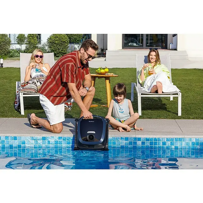 Beatbot Poolroboter AquaSense 2 - Akkubetrieben, Passend für: Pools bis 300 m² Grundfläche, Filterleistung: 20.800 l/h - Ein Mann setzt einen dunkelgrauen Beatbot Poolreinigungsroboter in einen Swimmingpool, während die Familie am Pool entspannt.