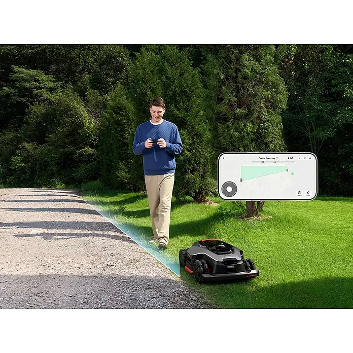 Dreame Mähroboter A3 AWD Pro 3500 - 3.500 m², Schnittbreite: 40 cm, Laser-gestützte Navigation, LiDAR - Mann nutzt Smartphone, um Grenze für schwarzen und roten Mähroboter auf Rasen zu erstellen.