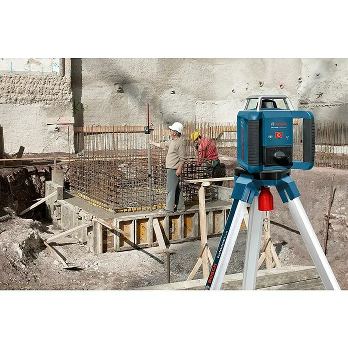 Bosch Professional Rotationslaser GRL 400 H PRO SET - Max. Arbeitsbereich mit Empfänger: 400 m, Mit Batterien - Blauer Bosch GRL 400 H Rotationslaser auf silbernem Stativ misst Pegel auf einer Baustelle mit Arbeitern.
