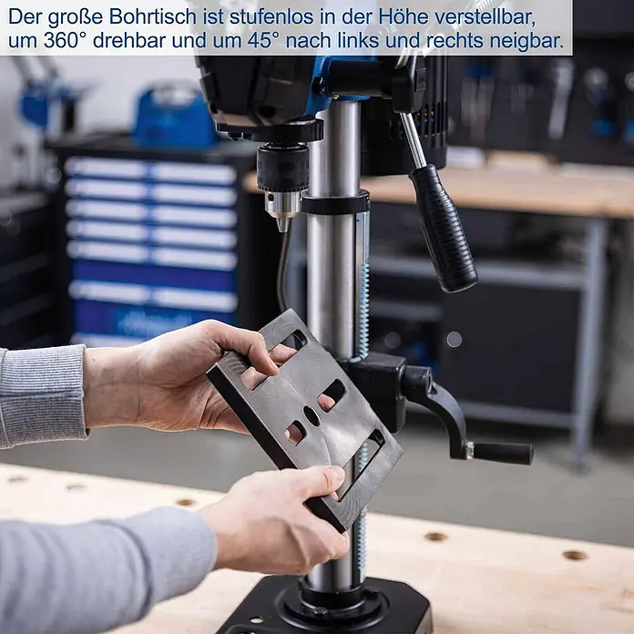 Scheppach Tischbohrmaschine TBM250 - 550 W, Leerlaufdrehzahl: 510 U/min - 2.430 U/min, Spannweite Bohrfutter: 1,5 mm - 13 mm - Hände halten einen dunkelgrauen, geschlitzten Bohrtisch, stufenlos höhenverstellbar, 360° drehbar und 45° neigbar.