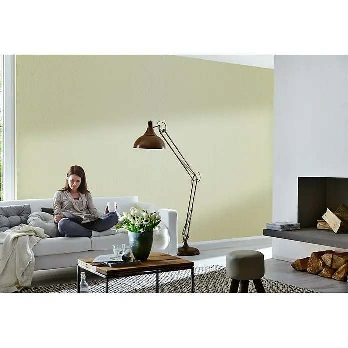 Knauf Rotband Flächenspachtel - 5 kg - Wohnzimmer mit großer Stehlampe im Vintage-Stil, die neben einer Couch und einem Kaffeetisch steht. Die Lampe spendet warmes Licht.