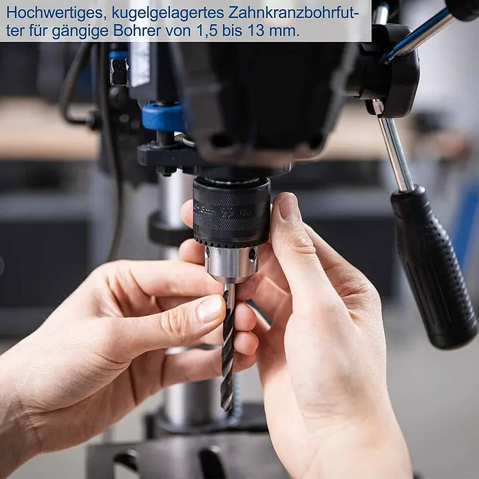Scheppach Tischbohrmaschine TBM250 - 550 W, Leerlaufdrehzahl: 510 U/min - 2.430 U/min, Spannweite Bohrfutter: 1,5 mm - 13 mm - Hochwertiges, kugelgelagertes Zahnkranzbohrfutter (1,5-13 mm) in Schwarz/Silber; Hände setzen einen Bohrer ein.