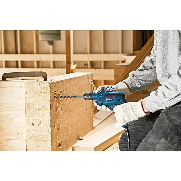 Bosch Professional Bohrmaschine GBM 10 RE - 600 W, ½″ Außenvierkant - Blauer Bosch GBM 10 RE Professional Bohrer in Gebrauch, bohrt in einen Holzbalken.