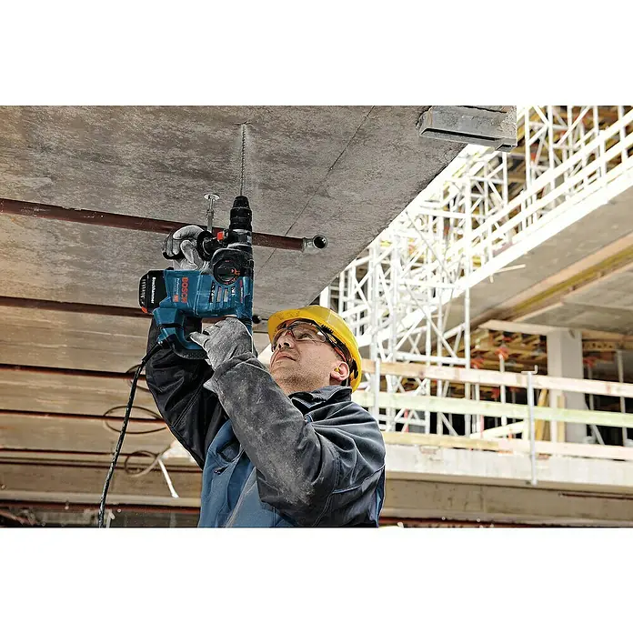 Bosch Professional Bohrhammer GBH 3-28 DFR - 800 W, 3,1 J, SDS-Plus-Aufnahme, Inkl. L-Boxx - Blauer Bosch Bohrhammer in Aktion, bohrt ein Loch in eine Betondecke.