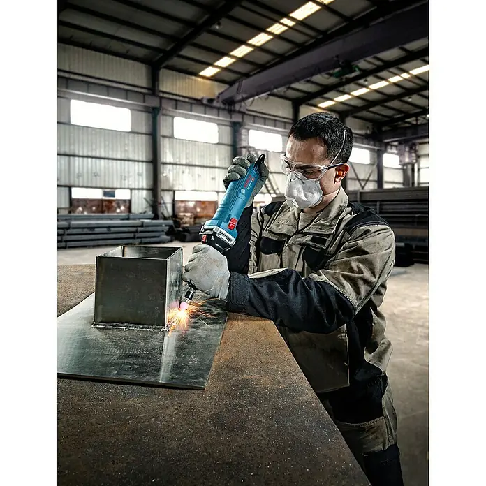 Bosch Professional Geradschleifer GGS 30 LS - 750 W, Leerlaufdrehzahl: 7.000 U/min - 33.000 U/min - Blauer und schwarzer Bosch Geradschleifer schleift Metall mit Funken, bedient von einem Arbeiter.