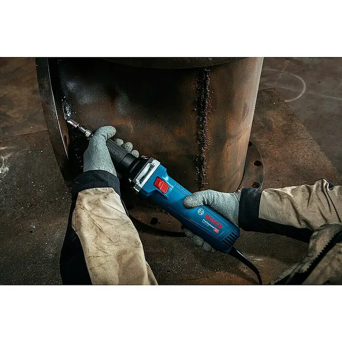 Bosch Professional Geradschleifer GGS 30 LS - 750 W, Leerlaufdrehzahl: 7.000 U/min - 33.000 U/min - Eine Person mit Handschuhen verwendet einen blauen Bosch Professional Geradschleifer, um eine Schweißnaht an einem rostigen Metallrohr zu glätten.