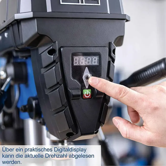 Scheppach Tischbohrmaschine TBM250 Vario - 600 W, Leerlaufdrehzahl: 1.490 U/min, Spannweite Bohrfutter: 3 mm - 13 mm - Hand drückt Knopf an schwarzem Bohrmaschinen-Bedienfeld mit Digitalanzeige und Netzschalter.