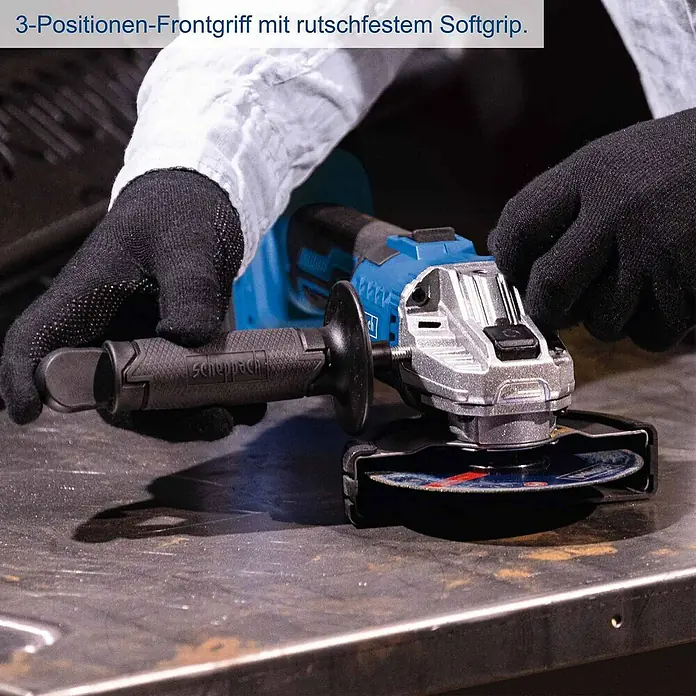 Scheppach IXES 20V Akku-Winkelschleifer C-ATB15/1-X - 1 Akku, 4 Ah, Durchmesser Scheibe: 125 mm - Eine Person mit schwarzen Handschuhen hält einen blauen und silbernen Akku-Winkelschleifer mit rutschfestem Griff auf einer Metalloberfläche.